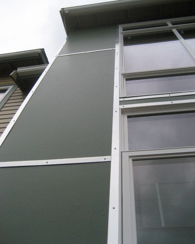 The exterior of the home is a mix of Hardiplank siding and panels with aluminum trim at the atrium.  It lends an industrial look to the facade, and adds interest to the entire home