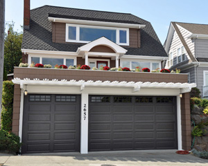 In its place, substantial 50-year roofing, new garage doors, and a delicate trellis framed out the garage opening, and new landscaping brightens the whole picture