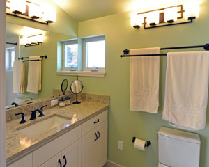 The bathroom is placed squarely in the corner of the new dormer, where it benefits from windows and bright interior colors. It includes a custom vanity and Pental cappuccino counters.