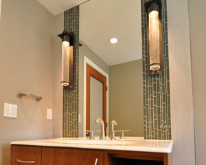 Back on the main floor, the new powder bath shines. The cabinet floats off the floor, with tile running underneathon the wall. A Kohler sink is the counter as well, with a crackled finish