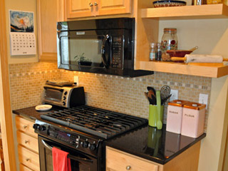 The entire stove area is relocated to where the dining table was, and a few added cabinets finish out the area