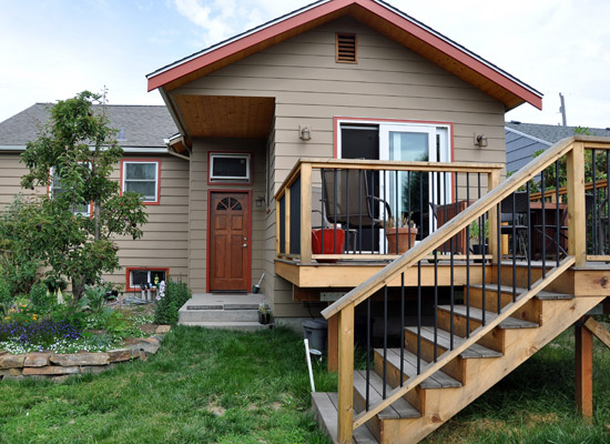 The new roof system was purposely designed to overhang the walkway to the grade-level door and create an overhang there.  The door previously had a small shed overhang that would have conflicted with the addition