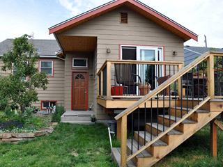 The new roof system was purposely designed to overhang the walkway to the grade-level door and create an overhang there.  The door previously had a small shed overhang that would have conflicted with the addition