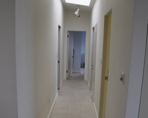 The hall started out all white, and the solution to that is some color.  The owners decided to trade out the doors for natural cherry, including a linen cabinet door