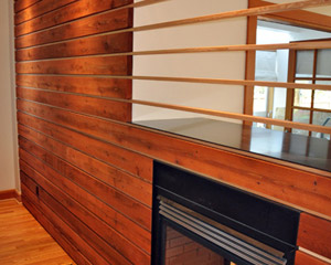 The natural wood is inset into a sheetrock frame to the left, and the VG fir extends through the fireplace opening, creating a clear delineation between the dining and living areas without blocking light