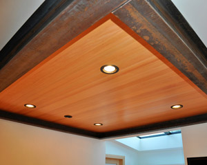 To remove the wall, a new steel beam was required. The architect turned that beam into a design feature, with decorative steel extending in a square around the new sitting/TV room adjacent to the kitchen. Infilled with good light and tongue and groove VG fir, this is a beautiful place to sit. The decision was made to leave the steel beams as is, which means they will patina over time