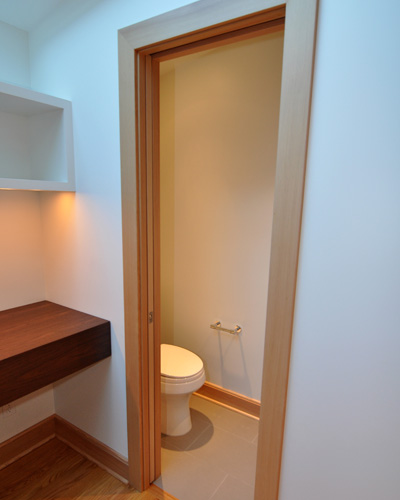 The powder room is conveniently tucked away with a laminated glass pocket door