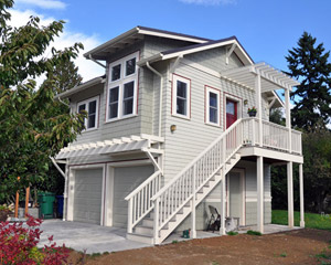 From the driveway, the cottage looks like a classic carriage house: two garage doors with a living space above.  The multiple windows are a sign that the space is more than standard