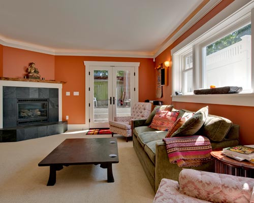 A comfortable, light and bright basement living room, with a salvaged wood mantle at the gas fireplace, daylight basement Seattle