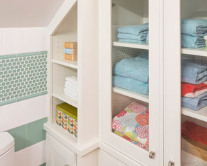 Built-ins at this bath make the most of the limited space by creating useful and accessible storage